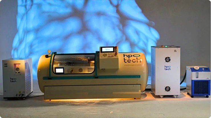 A landscape photo of the Trojan hyperbaric oxygen therapy (HBOT) chamber and its various units for air pressure and oxygen delivery.